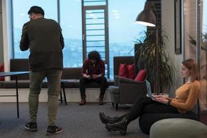 Two business women sitingt in a modern coworking space on a break from work and relax using a laptop. Selective focus photo