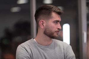 Portrait of happy millennial male business owner in modern office. Businessman, smiling and looking at camera. Leadership concept. Head shot. photo