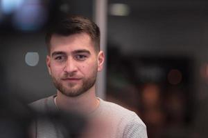 Portrait of happy millennial male business owner in modern office. Businessman, smiling and looking at camera. Leadership concept. Head shot. photo