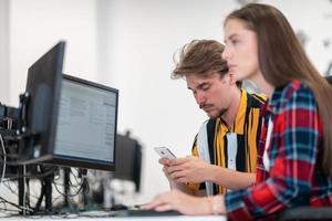 Business couple working together on project using tablet and desktop computer at modern open plan startup office. Selective focus photo
