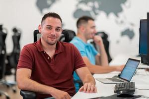 grupo de hombres de negocios casuales que trabajan en una computadora de escritorio en el moderno interior de la oficina de inicio de planta abierta. enfoque selectivo foto