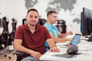 grupo de hombres de negocios casuales que trabajan en una computadora de escritorio en el moderno interior de la oficina de inicio de planta abierta. enfoque selectivo foto