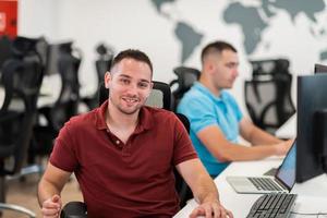 Group of Casual business man working on desktop computer in modern open plan startup office interior. Selective focus photo