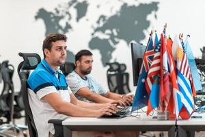 Group of Casual business man working on desktop computer in modern open plan startup office interior. Selective focus photo