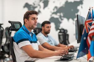 grupo de hombres de negocios casuales que trabajan en una computadora de escritorio en el moderno interior de la oficina de inicio de planta abierta. enfoque selectivo foto