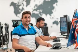 Group of Casual business man working on desktop computer in modern open plan startup office interior. Selective focus photo