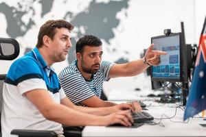 Group of Casual business man working on desktop computer in modern open plan startup office interior. Selective focus photo