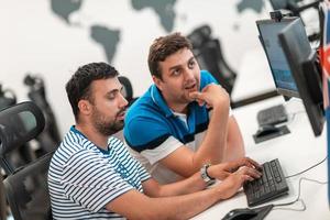 Group of Casual business man working on desktop computer in modern open plan startup office interior. Selective focus photo