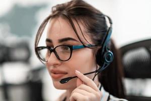 concepto de negocio y tecnología: operadora de la línea de ayuda con auriculares en el centro de llamadas. mujer de negocios con auriculares que trabajan en un centro de llamadas foto