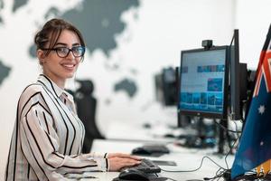 mujer de negocios informal que trabaja en una computadora de escritorio en el moderno interior de la oficina de inicio de planta abierta. enfoque selectivo foto