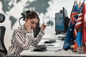 hermosa mujer joven sorprendida y molesta mirando su computadora portátil. mujer agente operadora triste que trabaja desde casa en un centro de llamadas foto