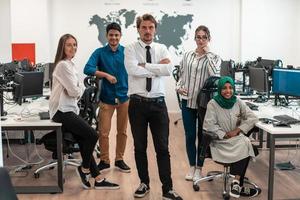 Portrait of young excited multiethnics business team of software developers standing and looking at camera at modern startup office photo