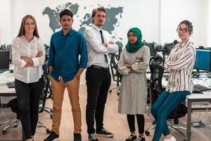 Portrait of young excited multiethnics business team of software developers standing and looking at camera at modern startup office photo