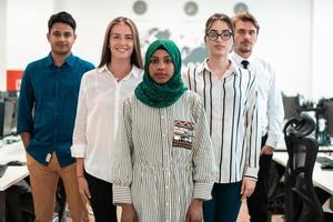 Portrait of young excited multiethnics business team of software developers standing and looking at camera at modern startup office photo