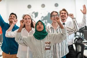 Portrait of young excited multiethnics business team of software developers standing and looking at camera at modern startup office photo