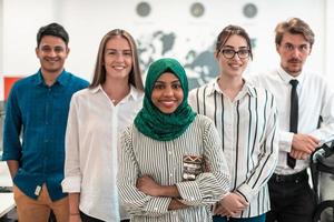 Portrait of young excited multiethnics business team of software developers standing and looking at camera at modern startup office photo