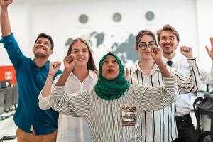 retrato de un joven equipo de negocios multiétnico emocionado de desarrolladores de software de pie y mirando la cámara en la oficina de inicio moderna foto