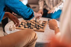 Multiethnic group of business people playing chess while having a break in relaxation area at modern startup office photo