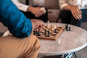 Multiethnic group of business people playing chess while having a break in relaxation area at modern startup office photo