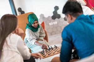 Multiethnic group of business people playing chess while having a break in relaxation area at modern startup office photo