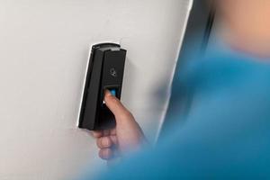 Man pressing fingerprint scanner on alarm system indoorsFinger print scan for unlock door security system photo