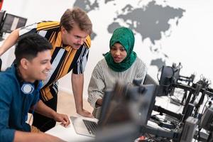 Multiethnic startup business team woman wearing a hijab on meeting in modern open plan office interior brainstorming, working on laptop and desktop computer. Selective focus photo