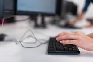 Close up programmer man hand typing on keyboard at desktop pc to input code language into software for study bug and defect of system at office for development of cyber security technology concept photo