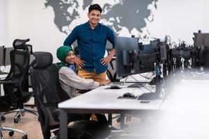 Multiethnic startup business team woman wearing a hijab on meeting in modern open plan office interior brainstorming, working on laptop and desktop computer. Selective focus photo