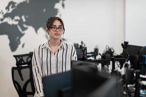 Portrait of businesswoman in casual clothes with glasses at modern startup open plan office interior. Selective focus photo