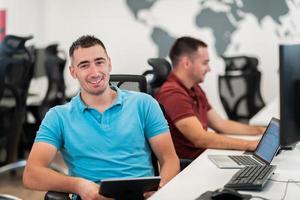 Group of Casual business man working on desktop computer in modern open plan startup office interior. Selective focus photo