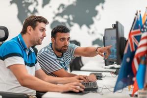 grupo de hombres de negocios casuales que trabajan en una computadora de escritorio en el moderno interior de la oficina de inicio de planta abierta. enfoque selectivo foto