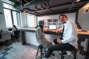 International multicultural business team.A young business man and woman sit in a modern relaxation space and talk about a new business. photo