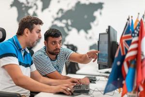 Group of Casual business man working on desktop computer in modern open plan startup office interior. Selective focus photo