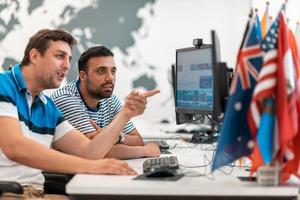 Group of Casual business man working on desktop computer in modern open plan startup office interior. Selective focus photo