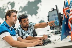 grupo de hombres de negocios casuales que trabajan en una computadora de escritorio en el moderno interior de la oficina de inicio de planta abierta. enfoque selectivo foto