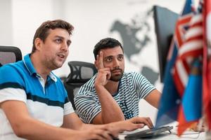 Group of Casual business man working on desktop computer in modern open plan startup office interior. Selective focus photo