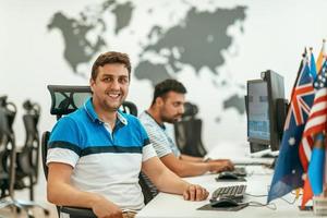 Group of Casual business man working on desktop computer in modern open plan startup office interior. Selective focus photo