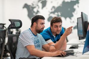 Group of Casual business man working on desktop computer in modern open plan startup office interior. Selective focus photo