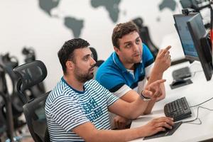 Group of Casual business man working on desktop computer in modern open plan startup office interior. Selective focus photo