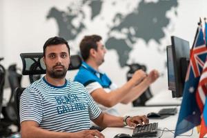 grupo de hombres de negocios casuales que trabajan en una computadora de escritorio en el moderno interior de la oficina de inicio de planta abierta. enfoque selectivo foto