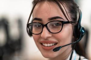 Business and technology concept - helpline female operator with headphones in call centre .Business woman with headsets working in a call center photo