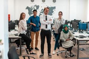 Portrait of young excited multiethnics business team of software developers standing and looking at camera at modern startup office photo