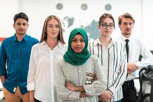 Portrait of young excited multiethnics business team of software developers standing and looking at camera at modern startup office photo