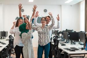 Portrait of young excited multiethnics business team of software developers standing and looking at camera at modern startup office photo