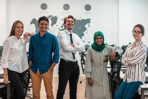 Portrait of young excited multiethnics business team of software developers standing and looking at camera at modern startup office photo