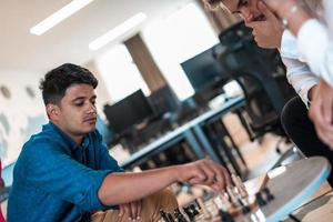 Multiethnic group of business people playing chess while having a break in relaxation area at modern startup office photo