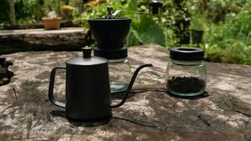 The drip coffee set includes coffee beans, drip kettle and a coffee grinder.  place on wooden table. photo