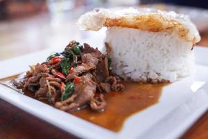 Stir fried beef with basil with fried egg on white plate It's a simple a la carte. that Thai people are very popular. photo