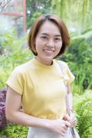 Asian woman with golden short hair wears a short sleeve t-shirt yellow color photo