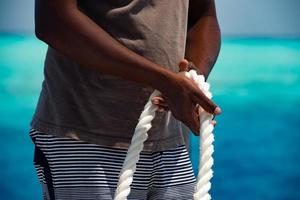 black hands holding white rope photo